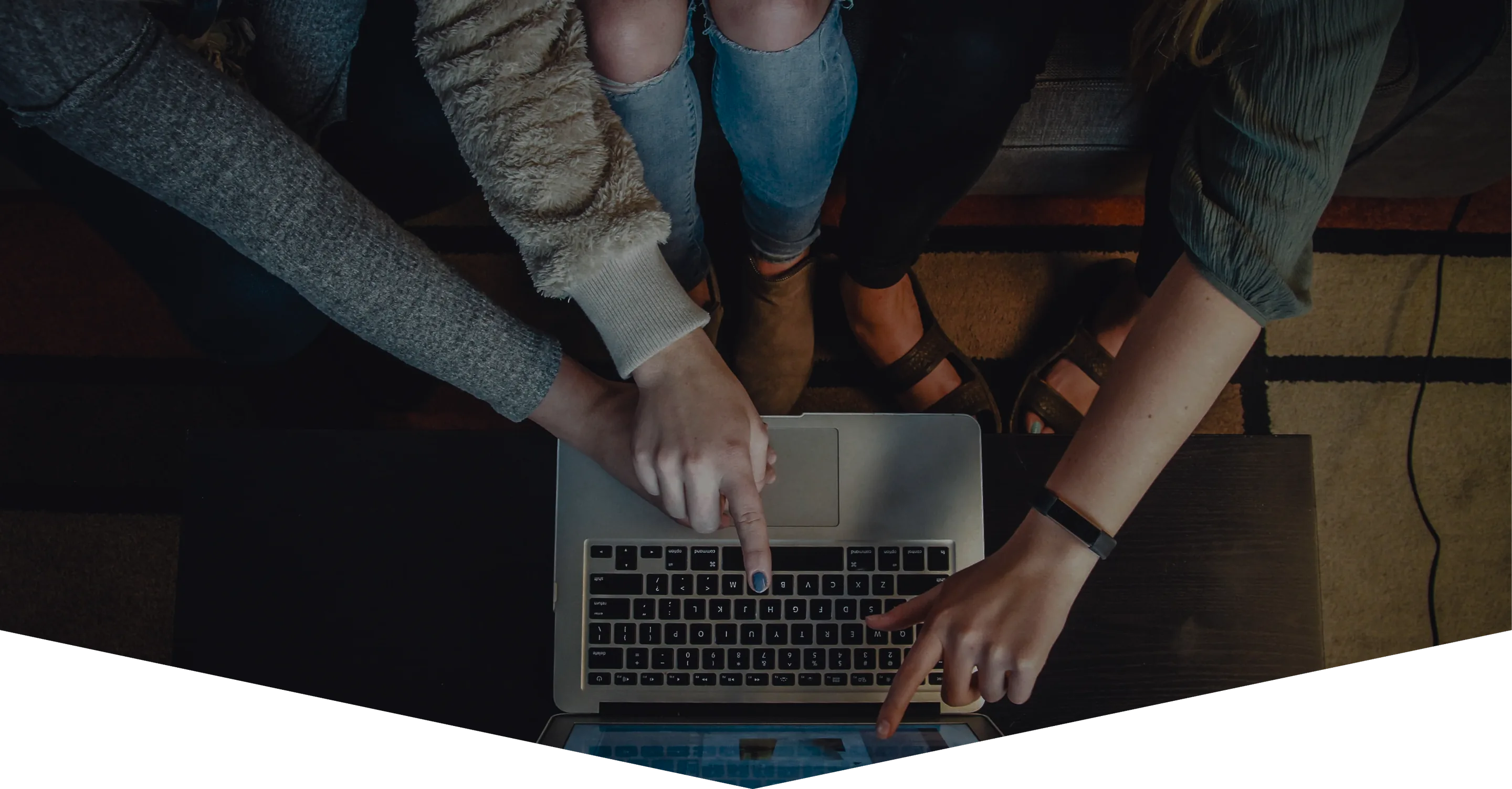 Equipe reunida ao redor de um notebook, vista de cima
